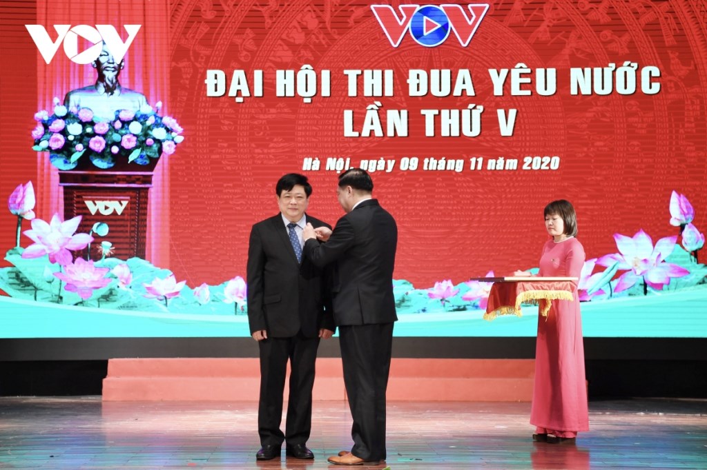 Le Manh Hung, chef adjoint de la Commission centrale de la propagande et de l’éducation décerne le titre 