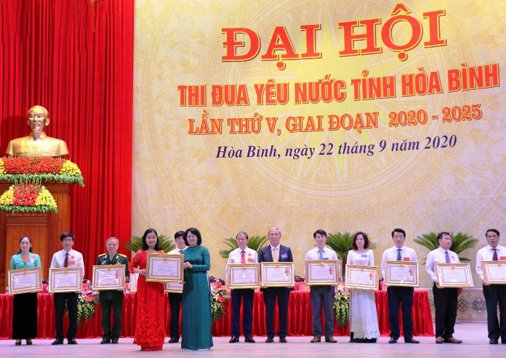 La vice-présidente de la République Dang Thi Ngoc Thinh remet  l’Ordre du Travail, le drapeau d’émulation et le satisfecit du Premier ministre aux collectifs et individus. Photo: NDEL