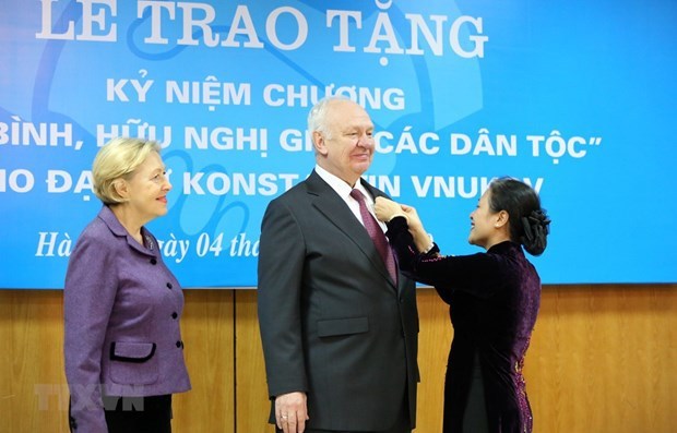 La présidente de l'Union des organisations d'amitié du Vietnam, Nguyen Phuong Nga, remet l'insigne 